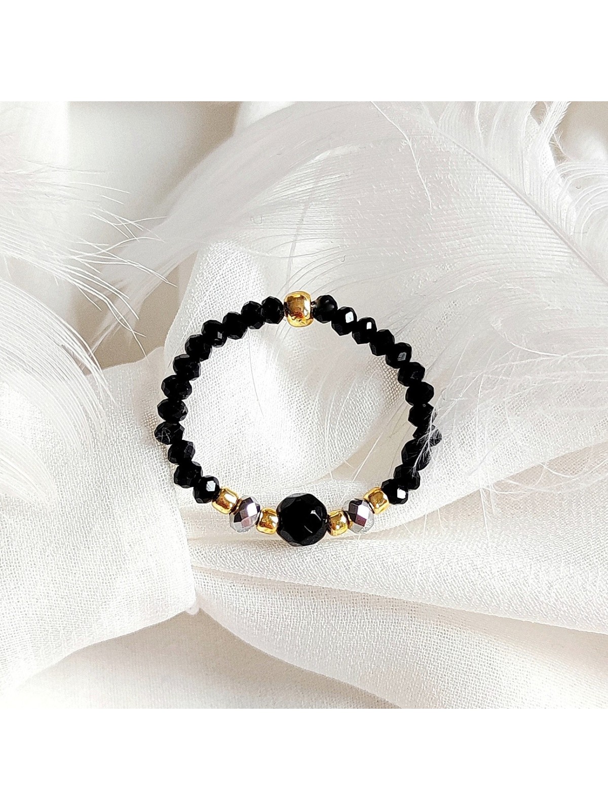 Pierścionek z jadeitem z czarnymi kryształkami i koralikami Toho w złotym odcieniu.