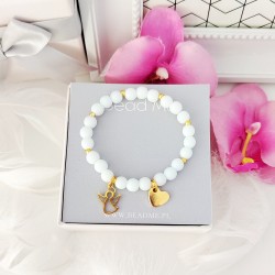 Bransoletka z białych koralików z serduszkiem z grawerem i złotym aniołkiem